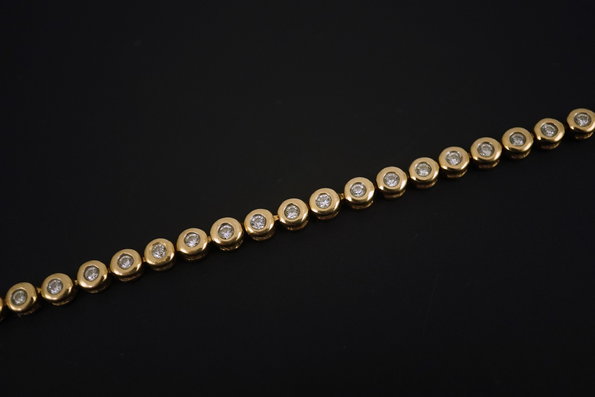 A modern gold and forty five stone round cut diamond set tennis bracelet